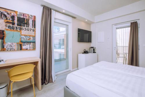 a hotel room with a bed and a desk and a window at Ah Porticcioli Boutique Apartments in San Felice del Benaco