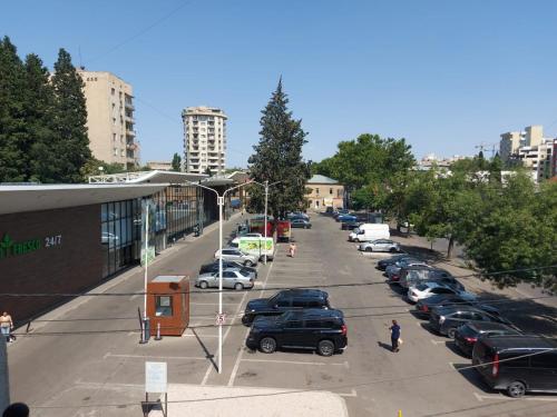 un estacionamiento con autos estacionados en una ciudad en Hotel ILZI en Tiflis