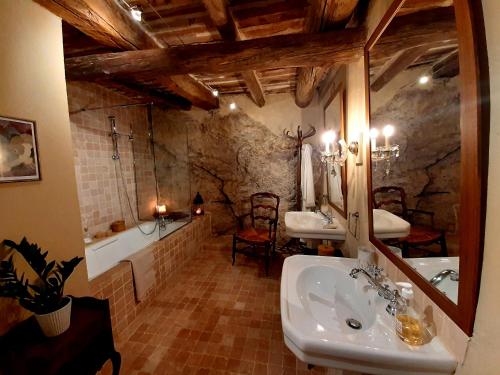 een badkamer met 2 wastafels, een bad en een spiegel bij La Vita Dolce, Luberon in Grambois