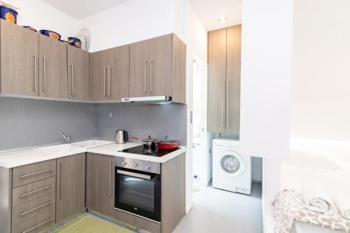 a kitchen with wooden cabinets and a stove at Alento Apartments in Tinos Town