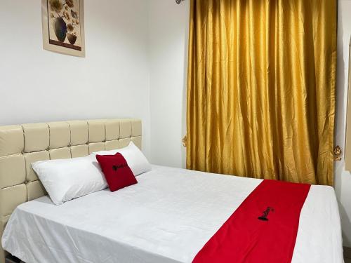 um quarto com uma cama com um cobertor vermelho em RedDoorz at Ring Road II Area Manado em Paniki