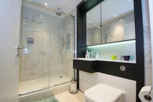 a bathroom with a shower and a toilet and a sink at Two-Bedroom Flat Chiswick in Kew Bridge