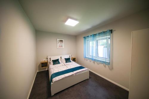 een slaapkamer met een bed en een raam bij Hori Homes Apartman in Siófok