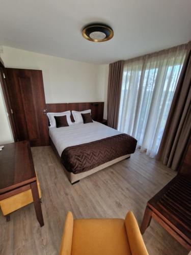 ein Schlafzimmer mit einem Bett, einem Tisch und einem Sofa in der Unterkunft Vikendica Aleksandrović Meterize in Topola