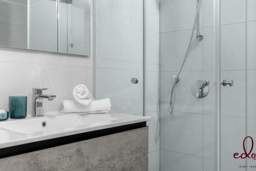 a bathroom with a shower and a sink and a shower at דירת סטודיו עם מרפסת במתחם סי סייד - By Edomlux in Eilat