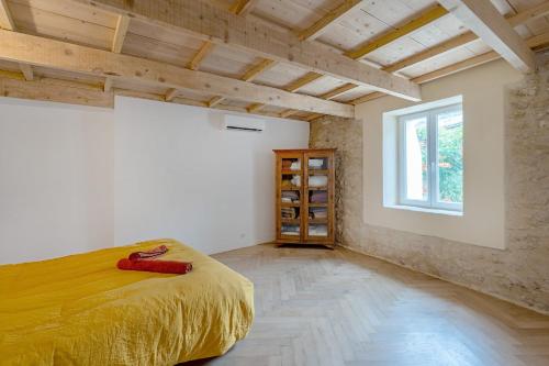 a bedroom with a bed in a room with a window at Rose Thé - Maison de village dans le Lubéron in Robion en Luberon