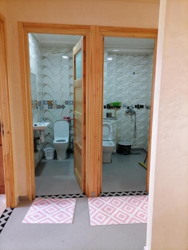 a bathroom with two toilets and a sink at apparts Large in Oualidia
