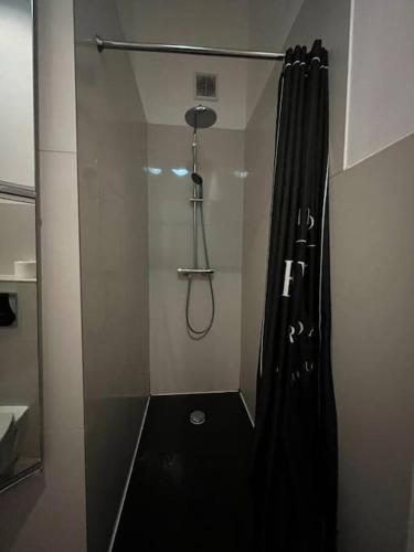 a shower with a black shower curtain in a bathroom at Apartment in the center in Łódź