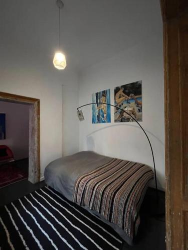 a bedroom with a bed and a lamp on the wall at Apartment in the center in Łódź