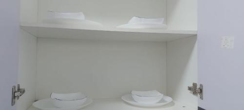 dwie toalety w białej łazience z dwoma półkami w obiekcie City Haven Accommodation-Two bedroom Apartment w mieście Nairobi