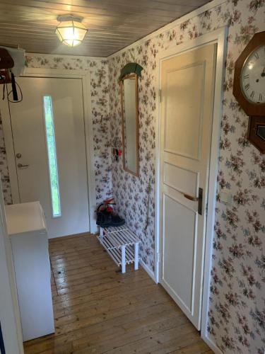 a room with a clock on the wall and a door at Cozy and Private 3-Bed House with bath Roslagen in Herräng