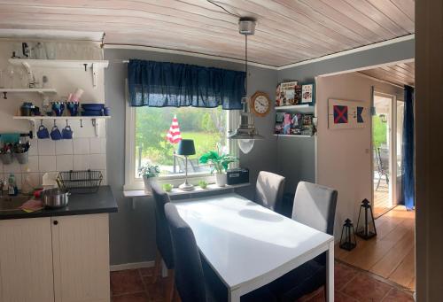 eine Küche und ein Esszimmer mit einem Tisch und Stühlen in der Unterkunft Cozy and Private 3-Bed House with bath Roslagen in Herräng