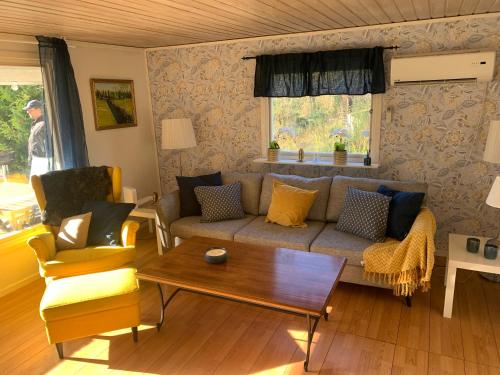 a living room with a couch and a table at Cozy and Private 3-Bed House with bath Roslagen in Herräng