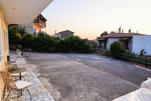 a yard with two chairs and a table and some houses at Ginas Apartment 1 in Kyparissia