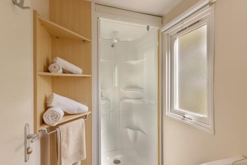 uma casa de banho com um chuveiro e uma porta de vidro em Camping du Grand Batailler em Bormes-les-Mimosas