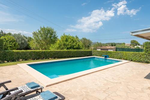 a swimming pool in a yard with two chairs at Vacaciones ideales en Villa Fernando con piscina! in Manacor