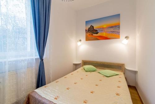 グディニャにあるMieszkanie Gdyniaのベッドルーム1室(壁に絵画が描かれたベッド1台付)