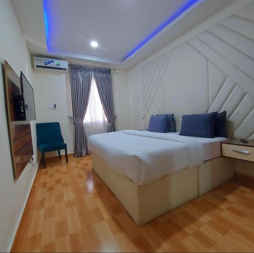 1 dormitorio con 1 cama grande con almohadas azules en Ziroc Apartments Lekki Phase 1 en Lagos