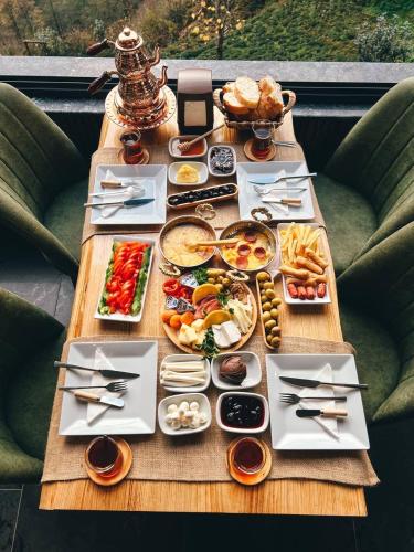 a table with plates of food on it at DELLA SUİT BUNGALOW in Çamlıhemşin