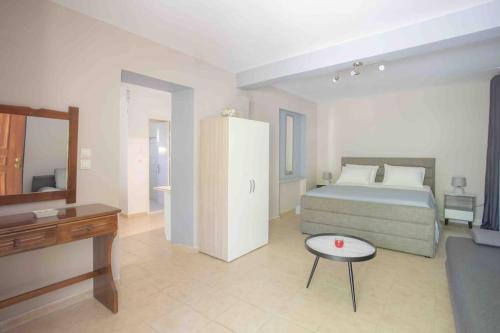 a bedroom with a bed and a tv and a table at Anthia private studio a breath away from beaches in Agios Nikitas