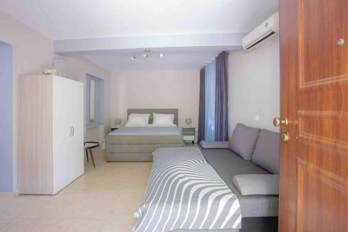 a living room with a couch and a bed at Anthia private studio a breath away from beaches in Agios Nikitas