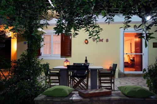 a patio with a table and chairs in a yard at Anthia private studio a breath away from beaches in Agios Nikitas