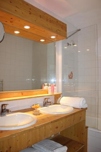 ein Badezimmer mit zwei Waschbecken und einem großen Spiegel in der Unterkunft Résidence Alpina Lodge by Valdiski in Val dʼIsère