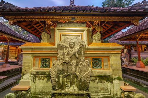a statue of a man in front of a building at Saren Kauh Ubud Palaceॐ in Ubud