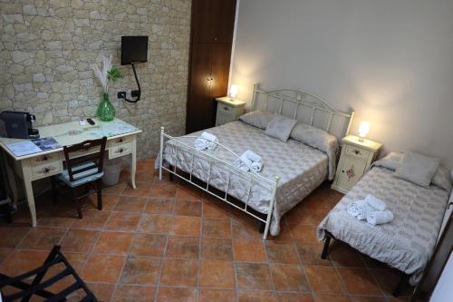 a bedroom with two beds and a desk and a desk at Rabatè in Agrigento