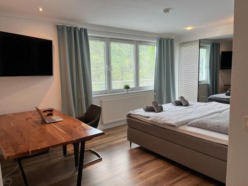 een slaapkamer met een bed en een houten tafel bij Bergpanorama - Suite Willingen in Willingen