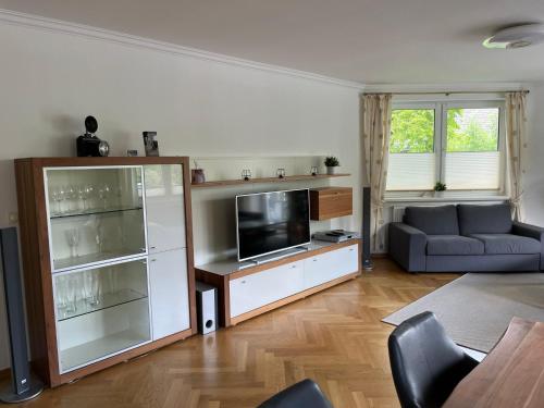 a living room with a couch and a television at Bergpanorama - Suite Willingen in Willingen