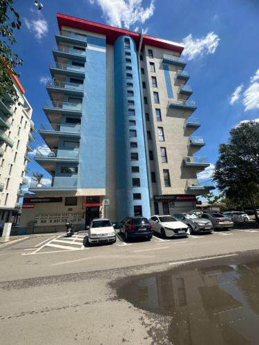 een groot gebouw met auto's geparkeerd op een parkeerplaats bij GGMamaia in Mamaia