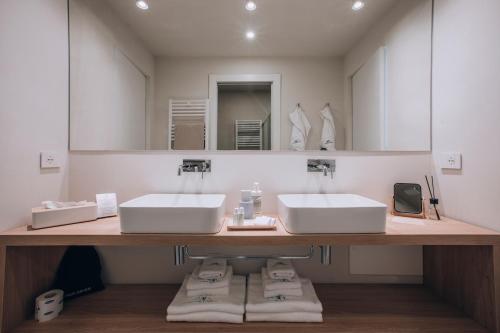 a bathroom with two sinks and a large mirror at Ah Porticcioli Boutique Apartments in San Felice del Benaco