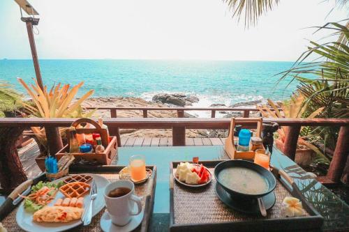 a table with a tray of food and the beach at Tongta Phaview Resort in Ko Samed