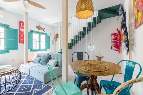 sala de estar con mesa y sillas azules en Petite Maison Victoria by Caleta Homes en Málaga
