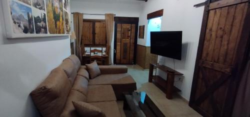 salon z kanapą i telewizorem z płaskim ekranem w obiekcie Corazón de Mágina w mieście Bedmar
