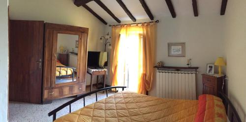 a bedroom with a bed and a dresser and a mirror at Agriturismo Poggio Paradiso in Mengara