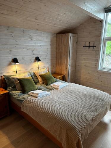 a bedroom with a large bed with two lamps on it at Large and cosy mountain cabin in Sykkylven