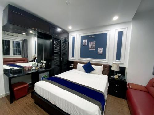 a bedroom with a large bed and a red chair at Eclipse Legend Hotel in Hanoi