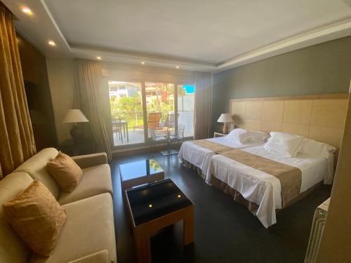 een hotelkamer met een bed en een bank bij ArtPlatinum SUITES&APARTMENTS in Benalmádena