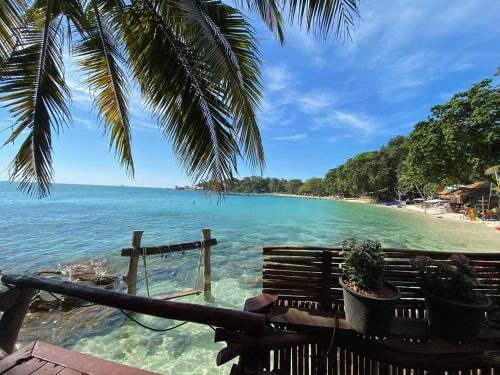 a view of a beach with a bench and the ocean at Tongta Phaview Resort in Ko Samed