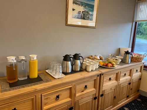 a wooden counter with food and orange juice on it at West Loch House in West Tarbert