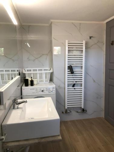 a white kitchen with a sink and a stove at Palio beach house in Paleo Tsifliki
