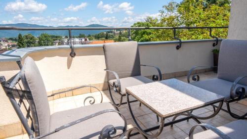een patio met stoelen en tafels op een balkon bij Apartments Biser in Vrnjačka Banja