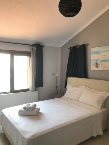 a bedroom with a bed with two towels on it at Palio beach house in Paleo Tsifliki