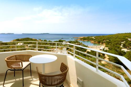 a balcony with chairs and a table and the ocean at TRS Ibiza Hotel - Adults Only in San Antonio