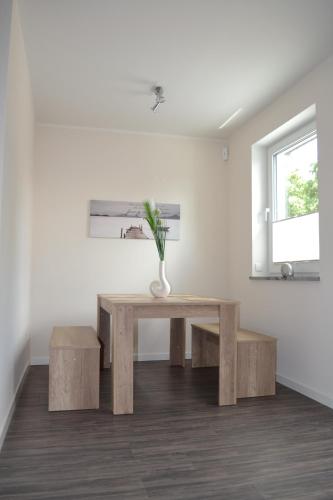 uma mesa e bancos num quarto com uma janela em Ostseeoase Kühlungsborn em Biendorf