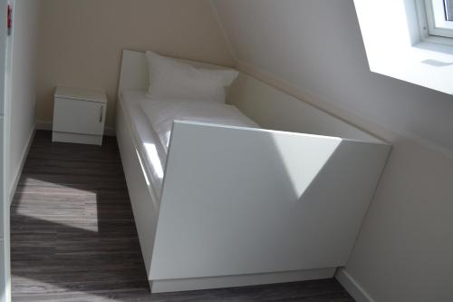uma pequena cama branca num quarto com uma janela em Ostseeoase Kühlungsborn em Biendorf