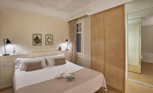 1 dormitorio con 1 cama blanca grande y ducha a ras de suelo en The Moods Catedral Hostal Boutique, en Barcelona