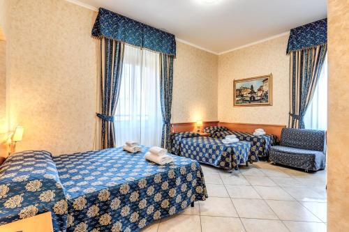 a hotel room with two beds and a chair at Hotel Orlanda in Rome